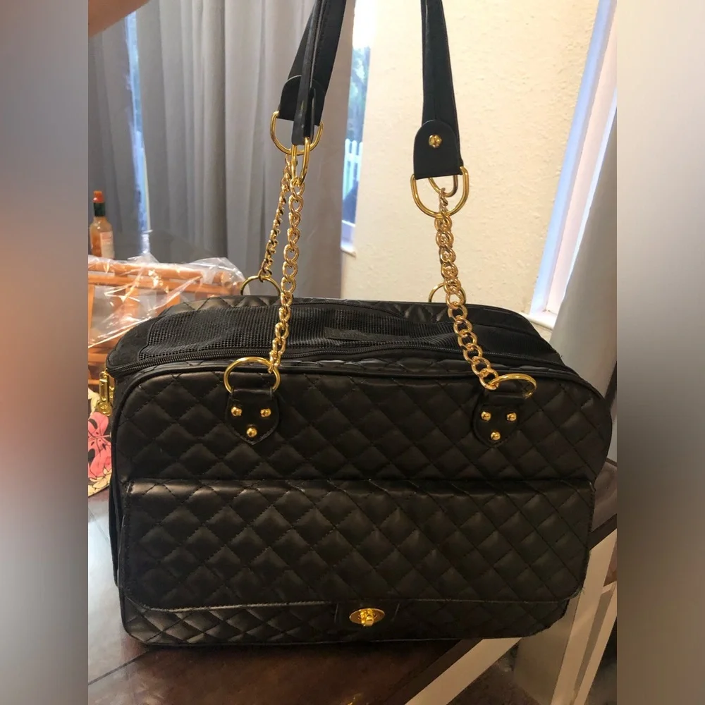 black quilted pet carrier tote with gold chain handles.